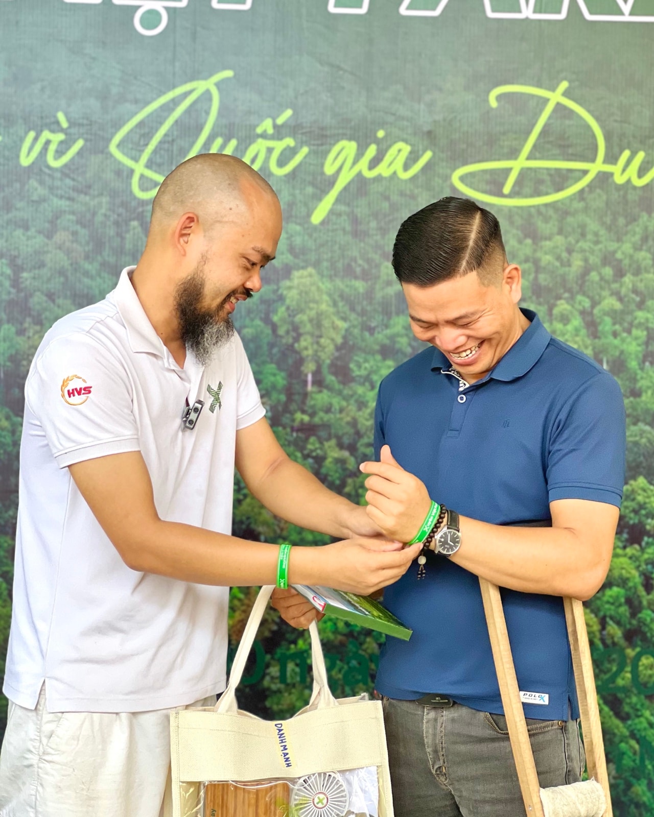 Thầy Phạm Thanh Tùng đeo vòng tay kỷ niệm hành trình cho Trần Danh Mạnh tại sự kiện Xuyên Việt Farmstay 2026